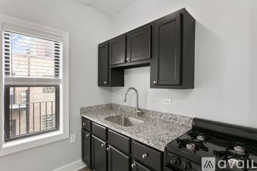 Chicago apartment for rent - A kitchen with black cabinets and a granite countertop.