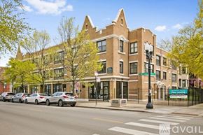 Chicago apartment for rent - A street view of a building with cars parked in front.