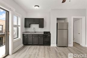 Chicago apartment for rent - A kitchen with black cabinets and a stainless steel refrigerator.