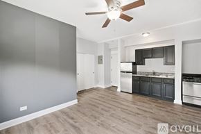 Chicago apartment for rent - A spacious kitchen with a ceiling fan and wooden flooring.