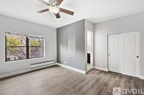 Chicago apartment for rent - A room with a ceiling fan and a window with a view of trees.