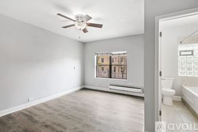 Chicago apartment for rent - A spacious room with a ceiling fan and a window overlooking a building.