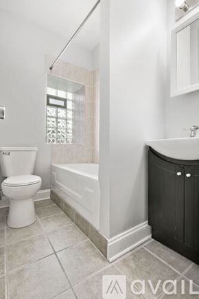Chicago apartment for rent - A bathroom with a toilet, sink, and bathtub.