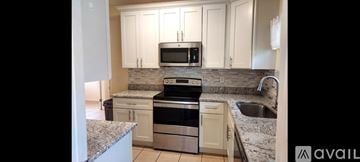 Kissimmee house for rent - A kitchen with granite countertops and stainless steel appliances is available for rent.