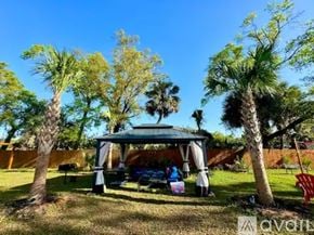 Pensacola house for rent - A family is sitting under a gazebo in a park.