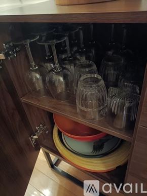 Surprise house for rent - A kitchen cabinet with glasses and plates stacked inside.