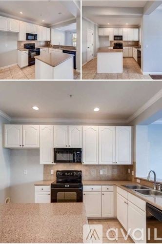 Orlando townhouse for rent - A kitchen with white cabinets and a black stove top oven.