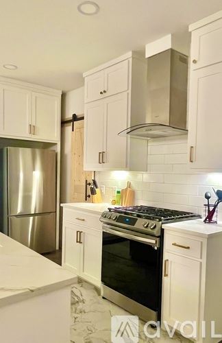Dallas house for rent - A modern kitchen with white cabinets and a large island.