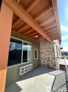 Missoula apartment for rent - A balcony with a wooden ceiling and a brick wall.