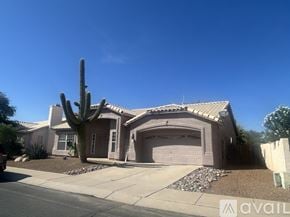 Tucson house for rent - A bathroom with a toilet, sink, and shower curtain.