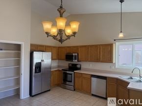 Tucson house for rent - A living room with a television, a couch, a chair, a table, and a wreath on the wall.