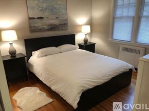 Charlotte townhouse for rent - A bedroom with a large bed and two lamps on either side of it.