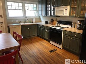 Charlotte townhouse for rent - A kitchen with wooden floors and a white stove top oven.