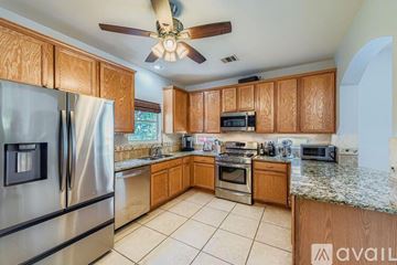 Austin house for rent - A kitchen with wooden cabinets and a stainless steel refrigerator.