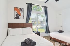 Waxahachie house for rent - A bedroom with a large bed and a painting on the wall.