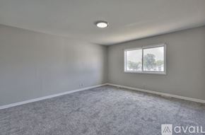 Nashville townhouse for rent - A room with grey carpet and a window showing trees outside.
