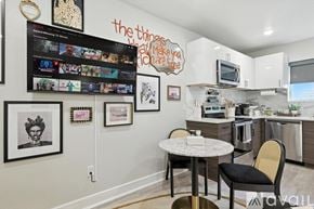 Dallas apartment for rent - A kitchen with a table and chairs in front of a wall with pictures and a TV.