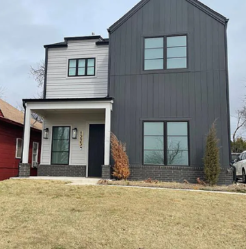 Oklahoma City house for rent - A modern two-story house with a grey exterior and a red house in the background.