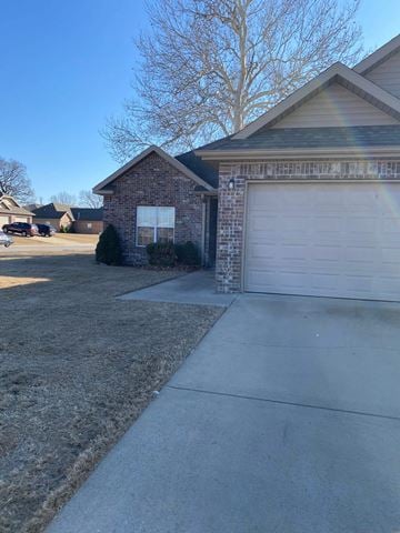 Centerton house for rent - A house with a garage door and a driveway.