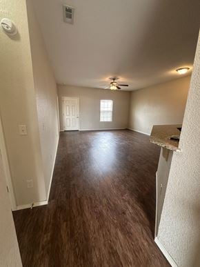 Centerton house for rent - A room with a ceiling fan and wooden flooring.