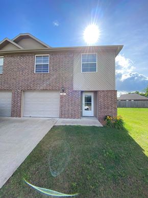 Centerton house for rent - A house with a garage door and a driveway.