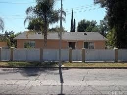 Reseda house for rent - A house with a white fence and trees in front.
