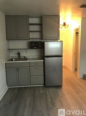 Naples apartment for rent - A kitchen with a refrigerator, microwave, and cabinets.