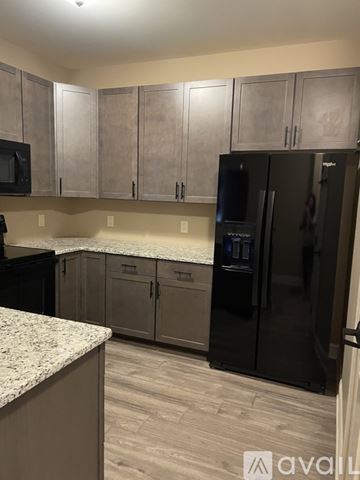 Quakertown apartment for rent - A kitchen with a black refrigerator and cabinets.