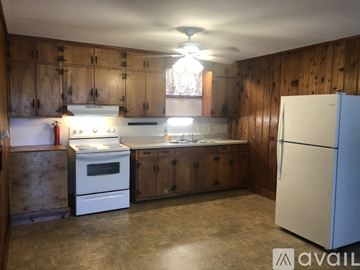 Dickson apartment for rent - A kitchen with wooden cabinets and a white refrigerator.