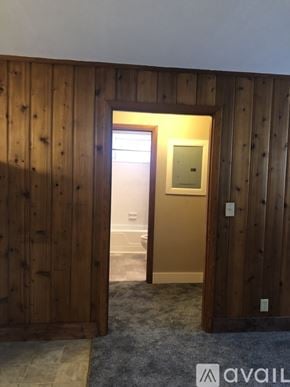 Dickson apartment for rent - A room with wooden walls and a doorway leading to another room.