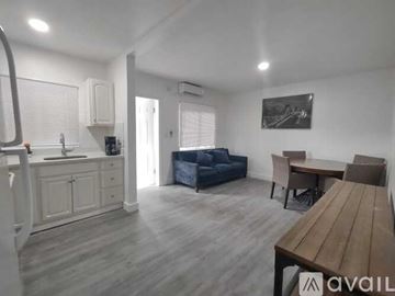 Miami apartment for rent - A living room with a blue couch, wooden table, and a painting on the wall.
