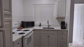 Miami apartment for rent - A kitchen with white appliances and cabinets.
