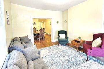 Cumberland house for rent - A living room with a grey couch and a patterned rug.