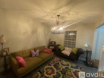 Cedar Hill house for rent - A living room with a brown couch and a chandelier.