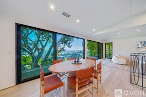 Los Angeles house for rent - A dining room with a table and chairs and a view of the outdoors through the window.