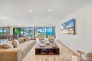 Los Angeles house for rent - A living room with a large couch and a flat screen TV mounted on the wall.
