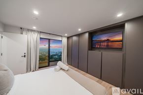 Los Angeles house for rent - A modern bedroom with a large bed and a television on the wall.