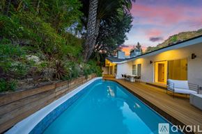 Beverly Hills house for rent - A pool in a backyard with a house and trees in the background.