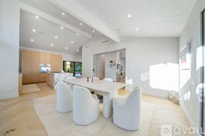 Beverly Hills house for rent - A modern dining room with a white table and chairs.