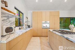 Beverly Hills house for rent - A kitchen with wooden cabinets and marble countertops.