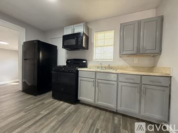 San Antonio apartment for rent - A kitchen with black appliances and grey cabinets.