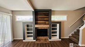 Spokane condo for rent - A modern living room with a fireplace and a staircase.