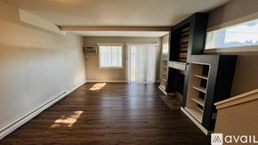 Spokane condo for rent - A spacious room with wooden flooring and a window with blinds.