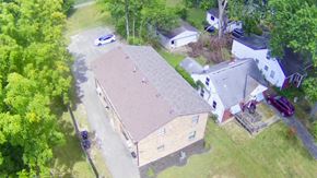 Louisville apartment for rent - A house with a brown roof is surrounded by trees.