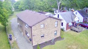 Louisville apartment for rent - A house with a brown roof is surrounded by greenery.