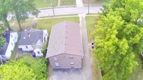 Louisville apartment for rent - A house with a brown roof is surrounded by trees.
