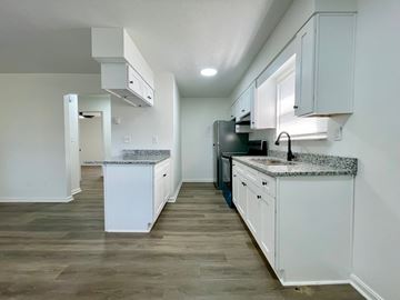 Louisville apartment for rent - A kitchen with white cabinets and a granite countertop.
