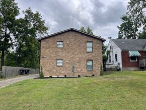 Louisville apartment for rent - A brick house with a green lawn in front.