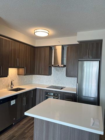 Burlington apartment for rent - A kitchen with a white counter top and brown cabinets.