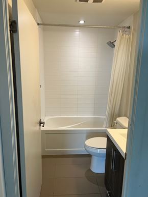 Burlington apartment for rent - A white toilet sits in a bathroom next to a bathtub.
